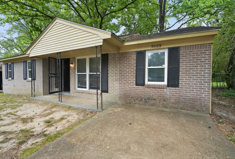 View of front facade with a patio and brick siding
