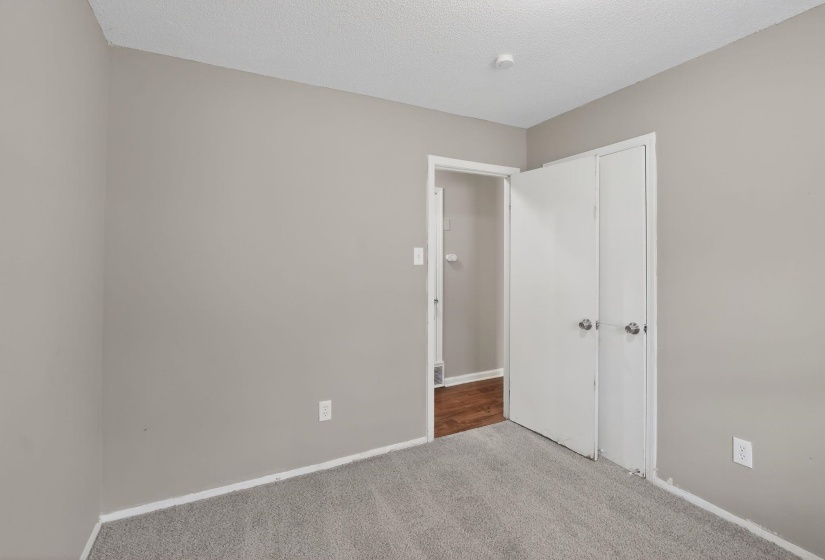 Unfurnished bedroom featuring carpet floors, a textured ceiling, and a closet