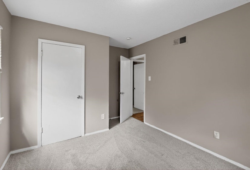 Unfurnished bedroom with baseboards and light carpet