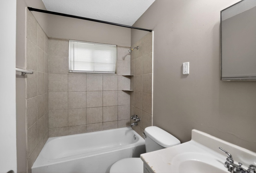 Full bath with vanity, bathtub / shower combination, and a textured ceiling