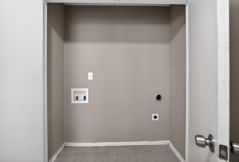 Laundry area with hookup for a washing machine, light tile patterned flooring, and electric dryer hookup