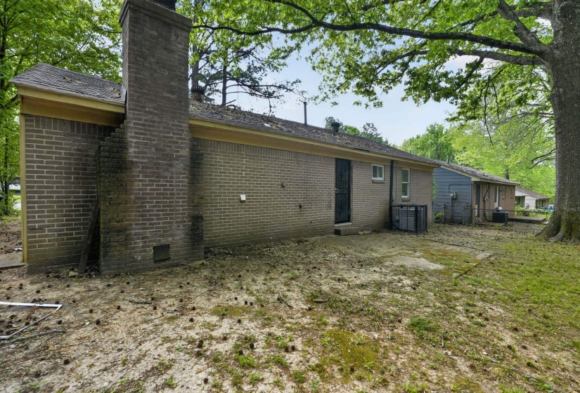Back of property featuring a chimney and brick siding