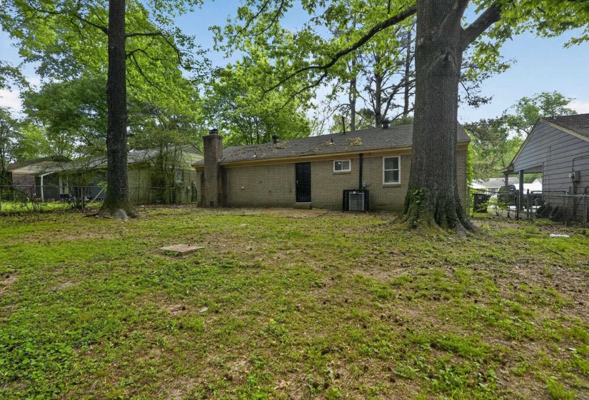 Rear view of property with brick siding and a chimney