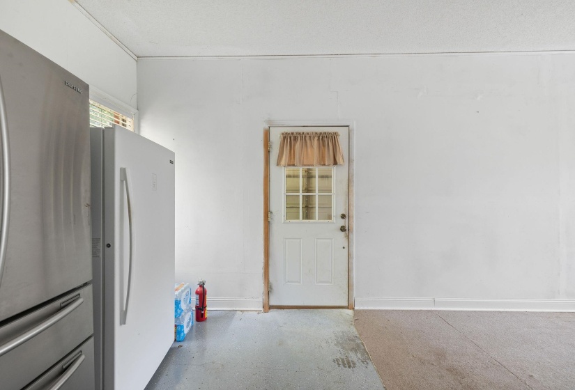 Kitchen with freestanding refrigerator and concrete flooring