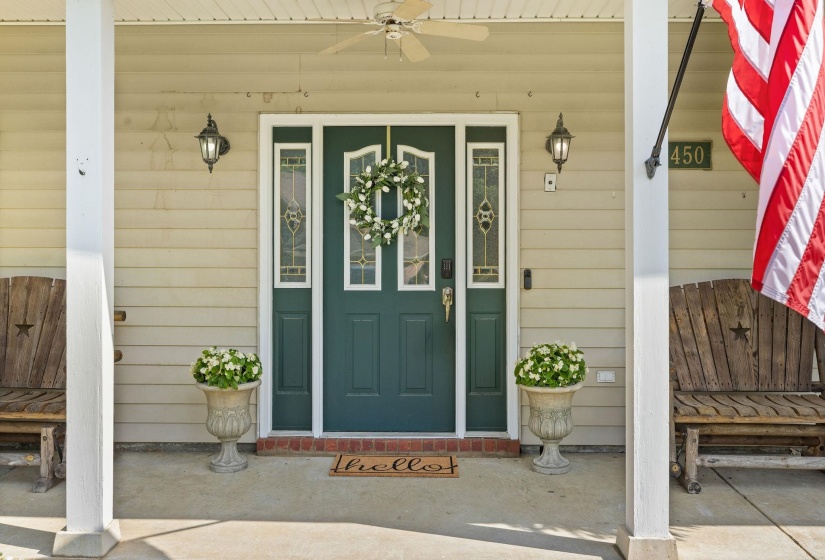 Entrance to property featuring covered porch and ceiling fan