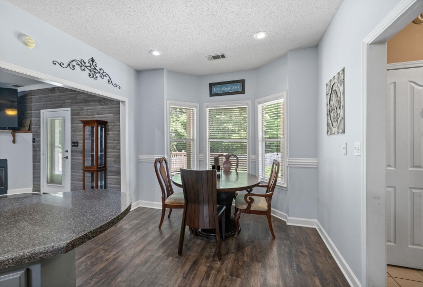 Dining area featuring a textured ceiling, recessed lighting, dark wood finished floors, and a fireplace