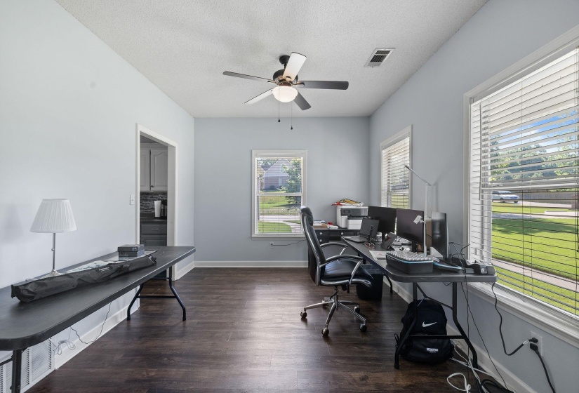 Office space featuring ceiling fan, a textured ceiling, and dark wood-type flooring