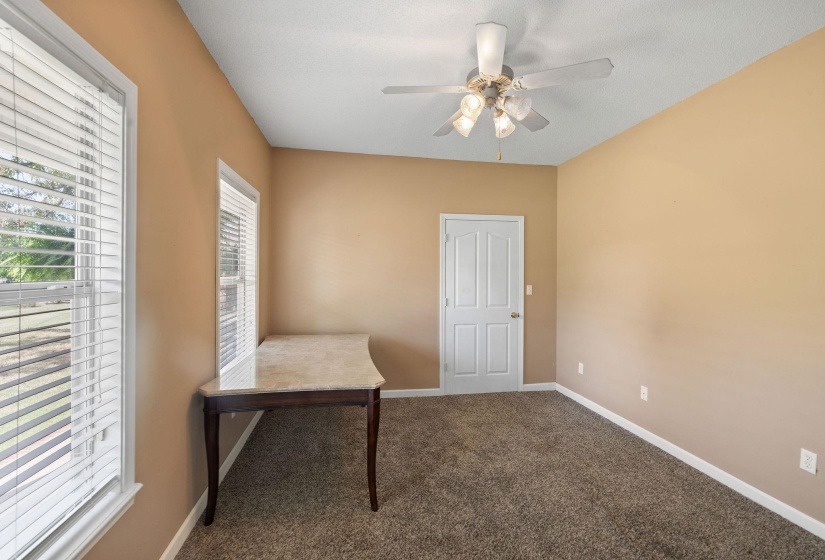 Unfurnished office with dark carpet and a ceiling fan