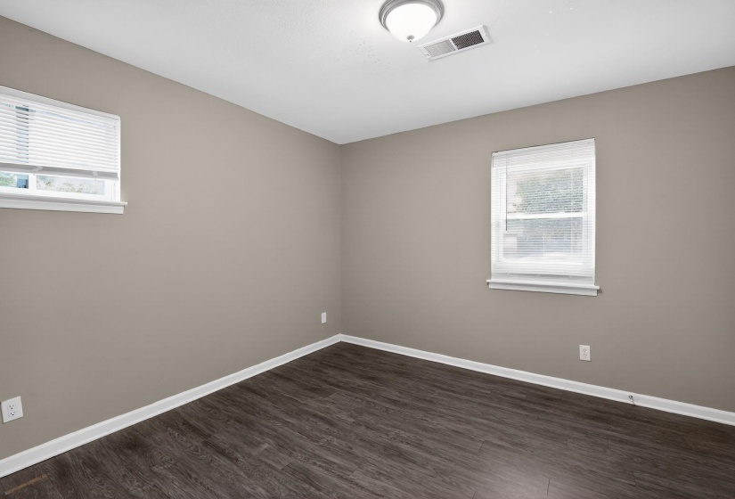 Unfurnished room with dark wood-type flooring and baseboards