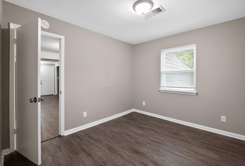 Spare room with baseboards and dark wood finished floors