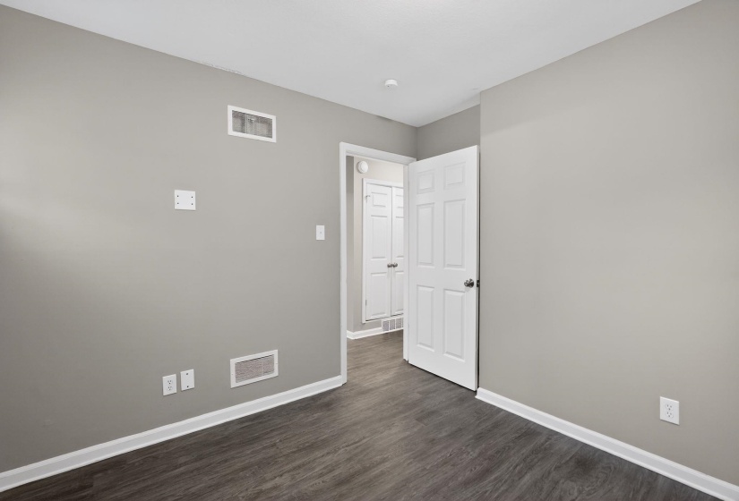 Unfurnished room featuring baseboards and dark wood finished floors
