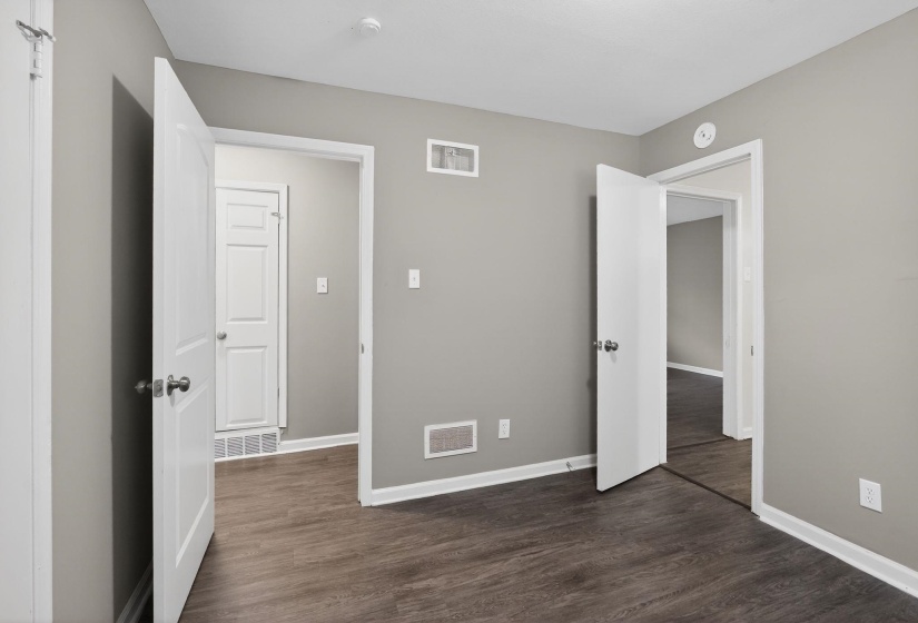 Unfurnished bedroom with dark wood-style flooring