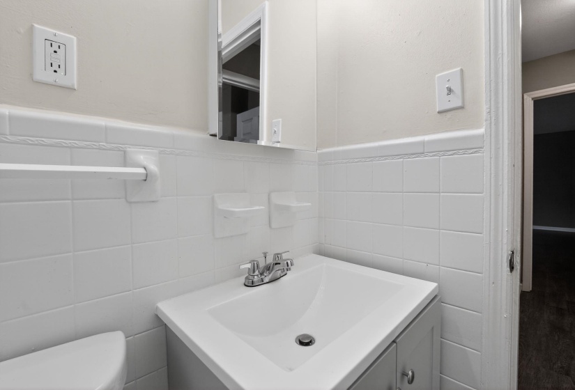 Bathroom with vanity, a wainscoted wall, and tile walls