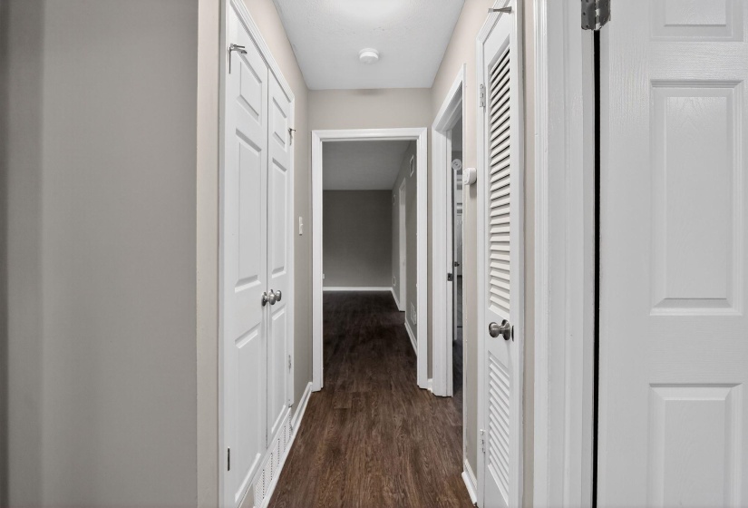 Corridor featuring dark wood-type flooring and baseboards