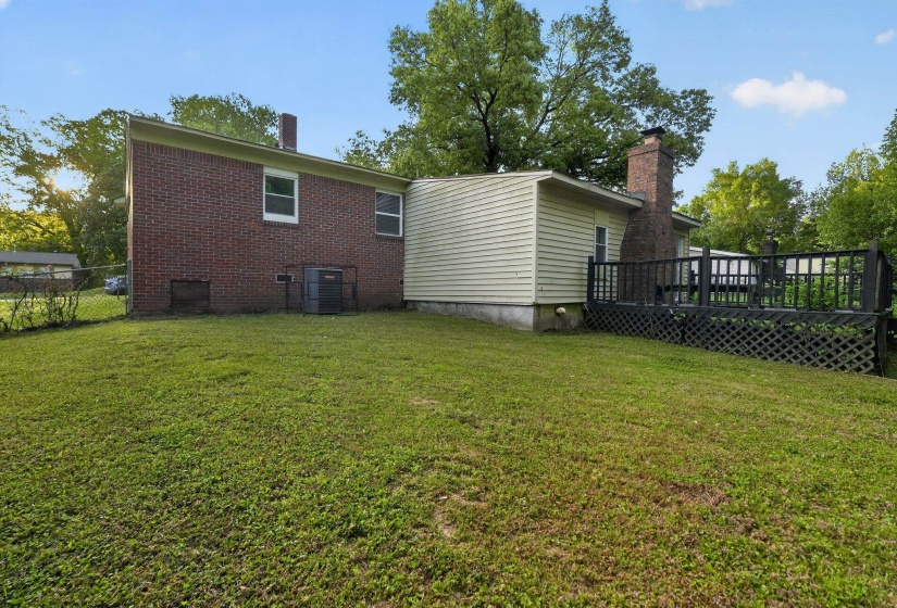 Rear view of house with a chimney, a wooden deck, and brick siding