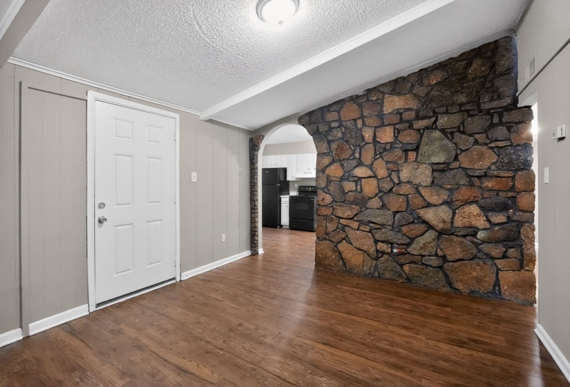 Foyer with arched walkways and dark wood-type flooring