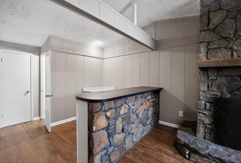 Bar with dark wood-style flooring and a fireplace