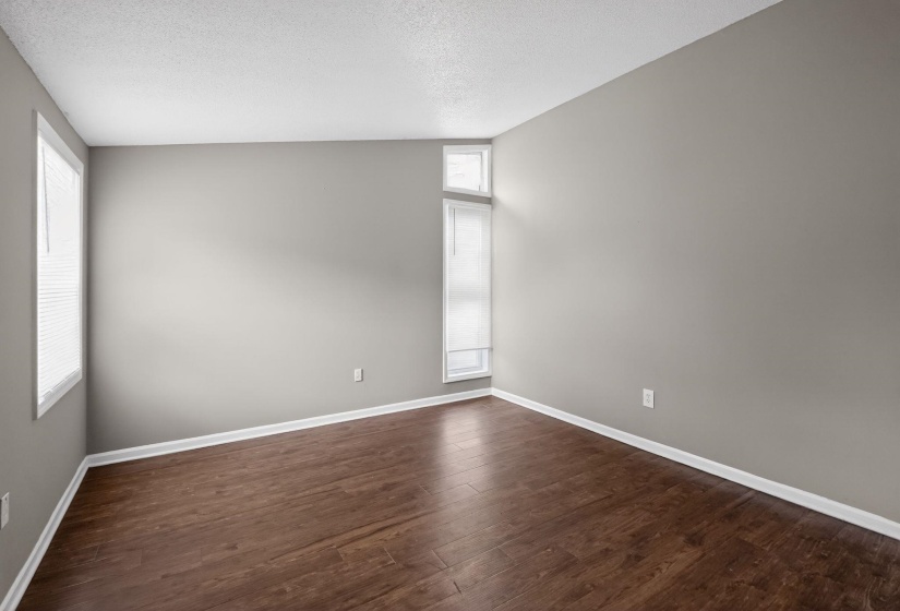 Unfurnished room featuring a textured ceiling and dark wood-type flooring
