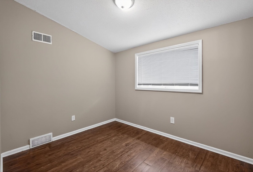 Spare room with baseboards and dark wood-style floors