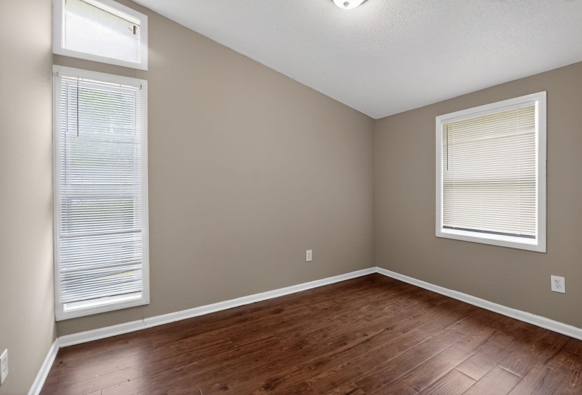 Spare room featuring baseboards and dark wood-style flooring