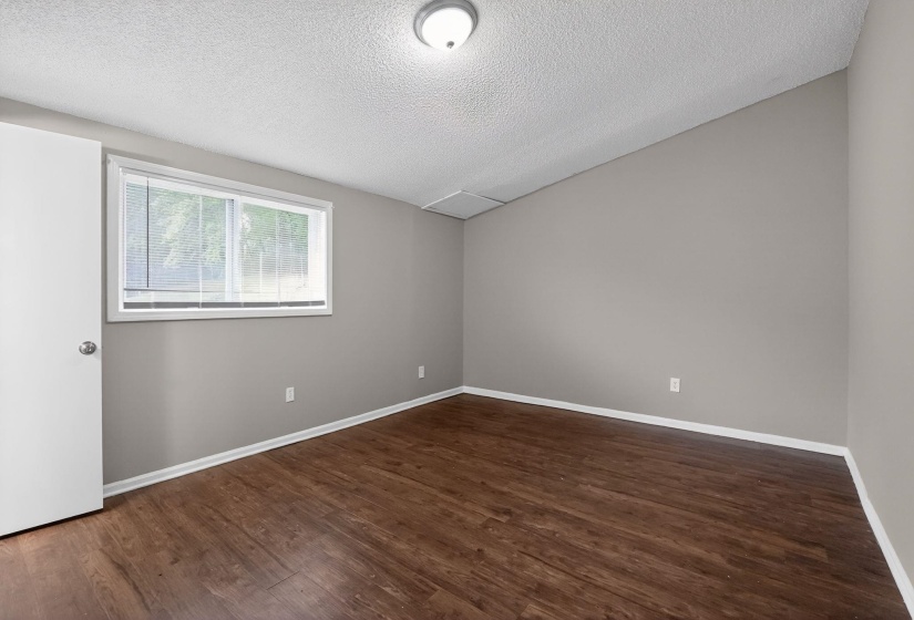 Unfurnished room with a textured ceiling and dark wood-style floors