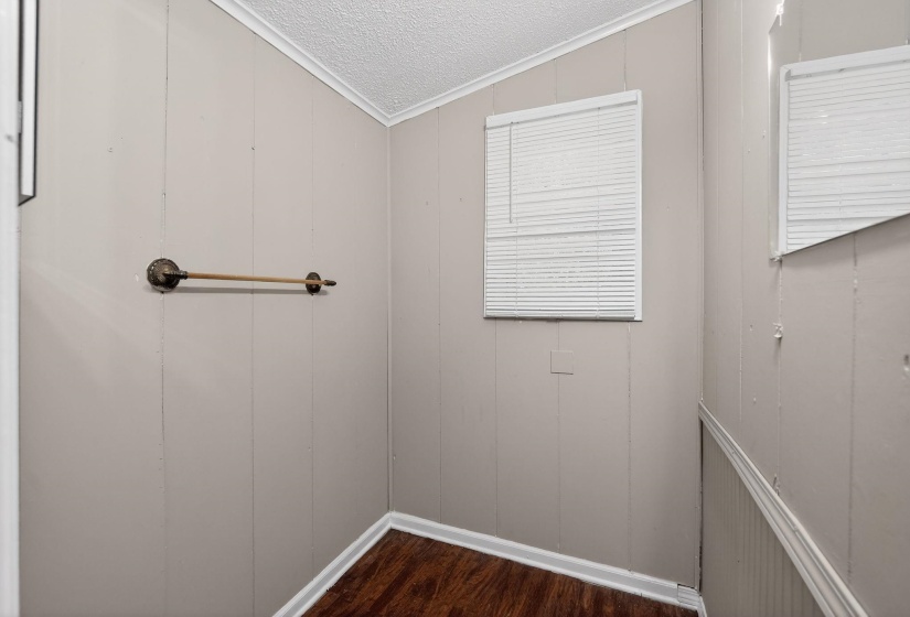 Spare room with a textured ceiling, dark wood-type flooring, and ornamental molding