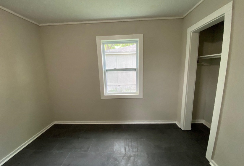 Unfurnished bedroom with ornamental molding and a closet