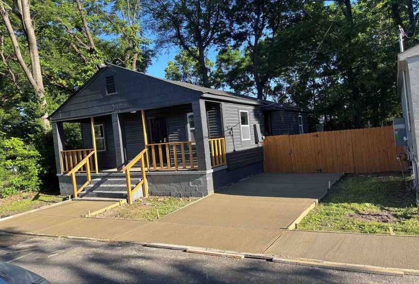Single-story residence featuring dark gray siding and a covered front porch with natural wood railings