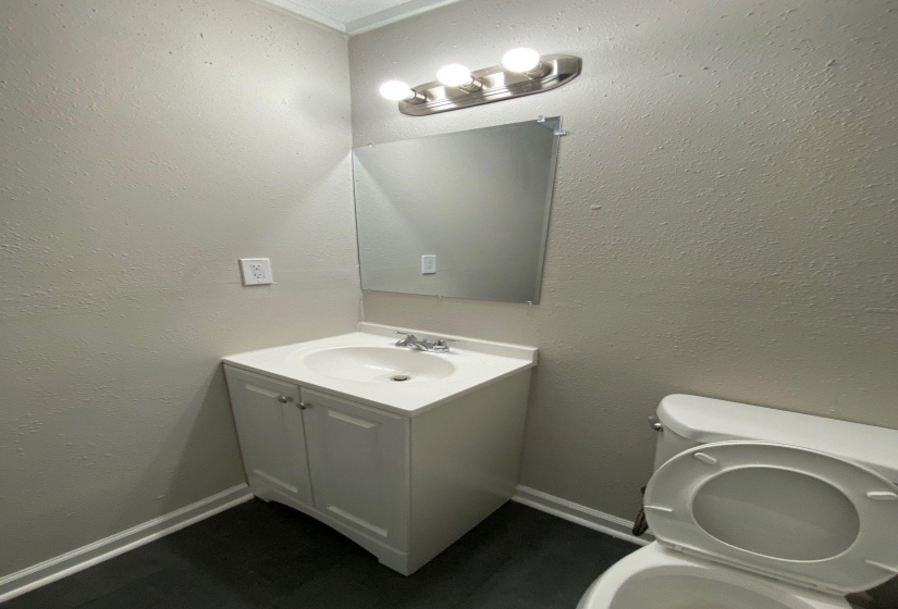 Bathroom with vanity and a textured wall
