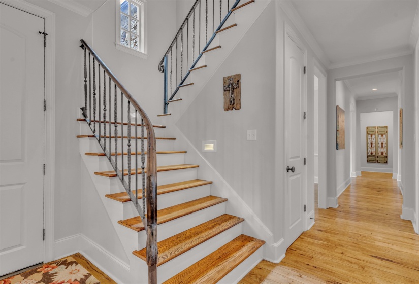Curved staircase with wood treads and a wrought iron railing