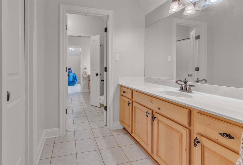 Full bath with vanity, light tile patterned floors, and a shower with shower curtain