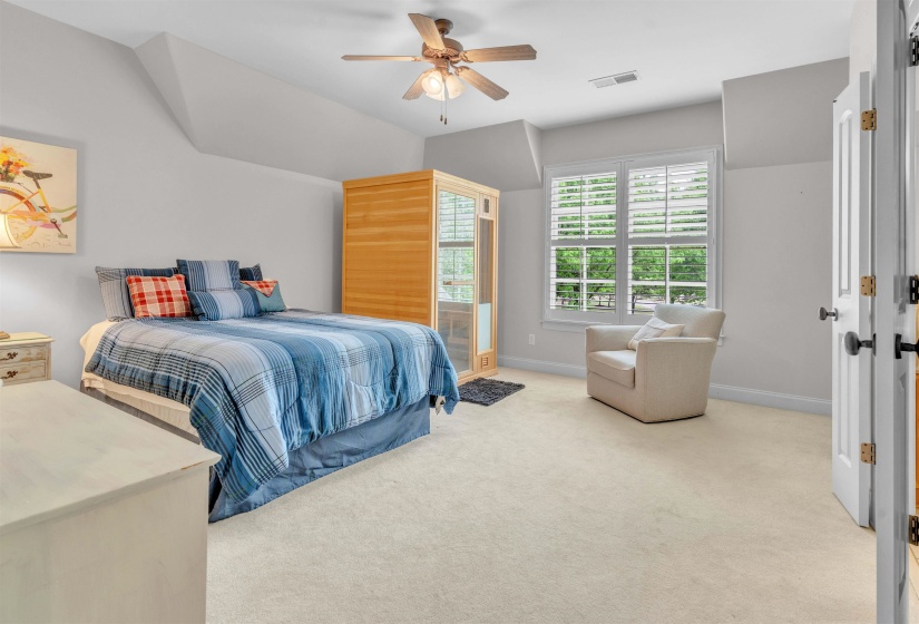 Bedroom featuring light carpet, ceiling fan, and lofted ceiling