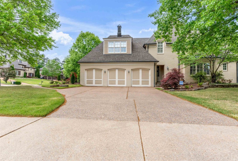 View of front of property with a front lawn, concrete driveway, a shingled roof, an attached garage, and stucco siding