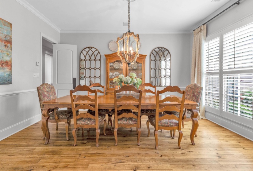 Dining room with hanging lights, light wood-style flooring, and ornamental molding