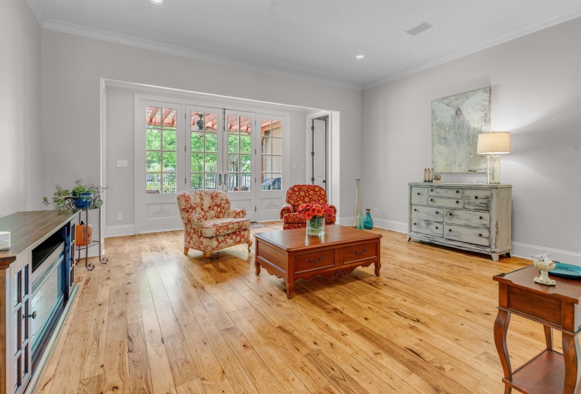 Sitting room with crown molding, light wood finished floors, and recessed lighting