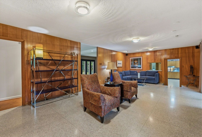 DEN/FAMILY ROOM (28x15) with classic paneling, sliding glass door to the   Backyard, and convenient pass-through to the Kitchen - perfect for relaxed living.