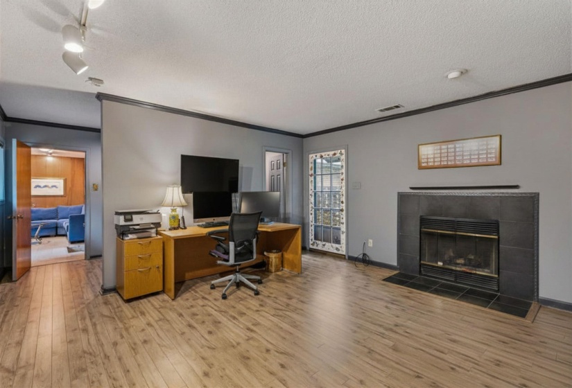 OFFICE/2nd LIVING ROOM features wood-burning fireplace and LVP flooring, located near a Half Bath for convenience.