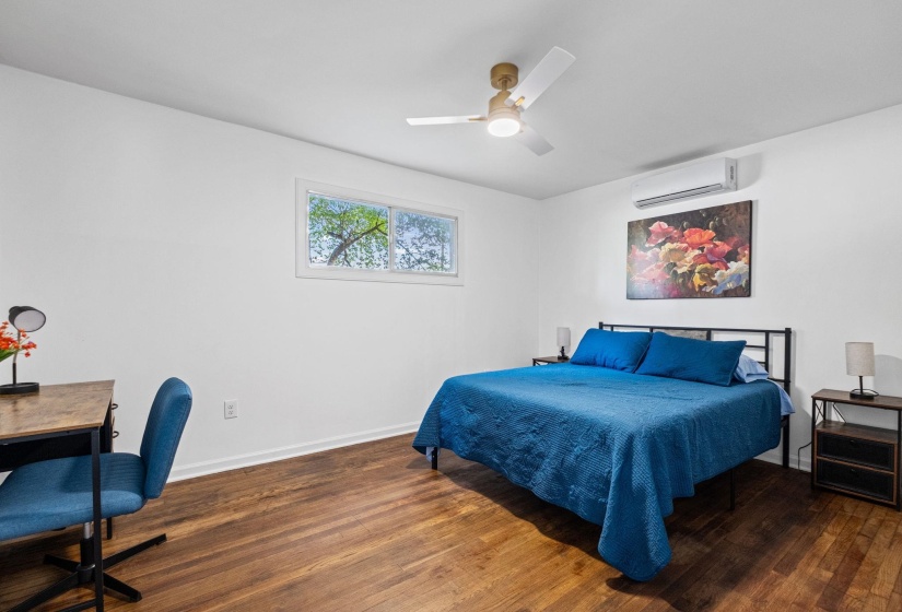 Bright room featuring wood-finish flooring, white walls, and a window providing natural light