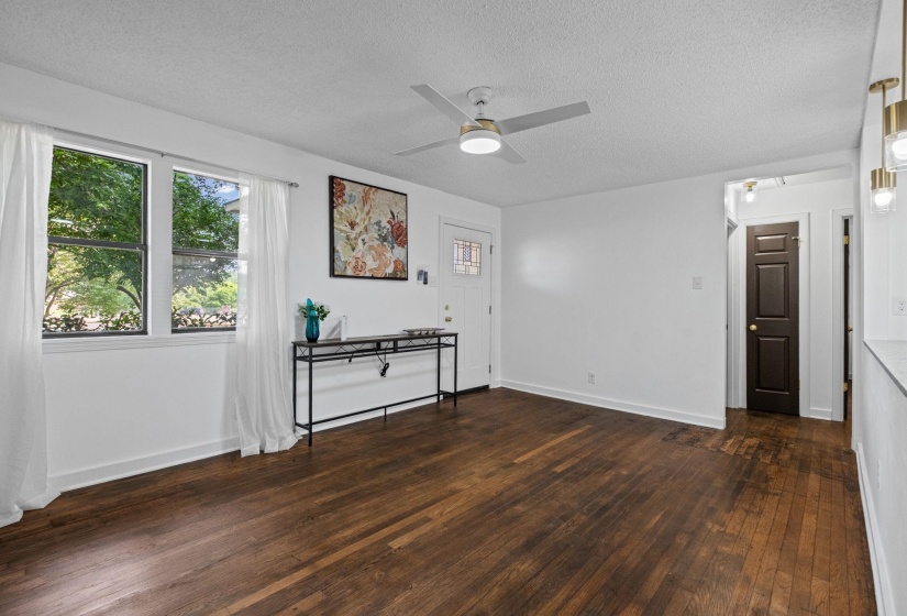 Hardwood flooring extends throughout this interior space, complemented by white walls and trim
