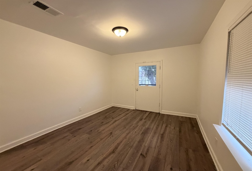 Spare room with baseboards and dark wood-style floors