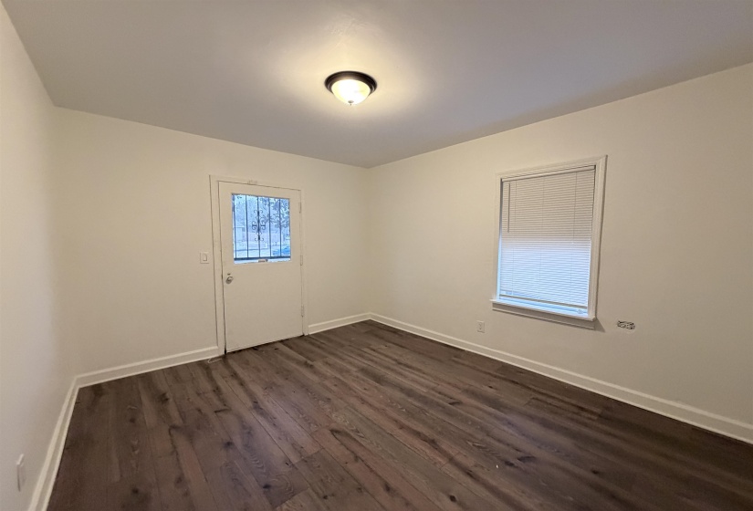 Spare room with dark wood-style floors and baseboards