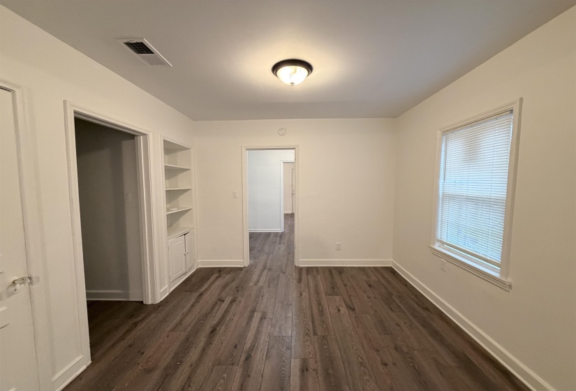 Unfurnished dining area with dark wood-style flooring and built in features