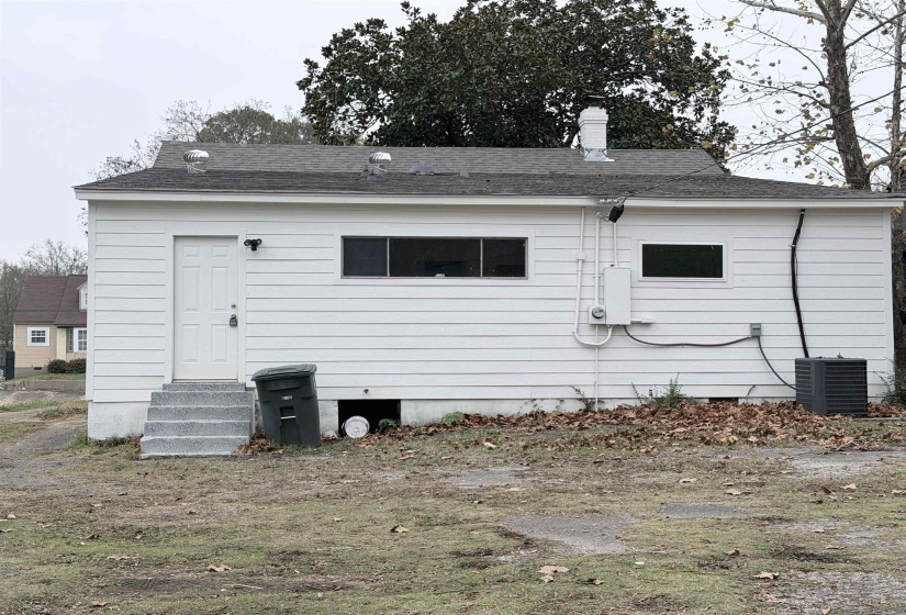 Back of property featuring a shingled roof, a chimney, and entry steps
