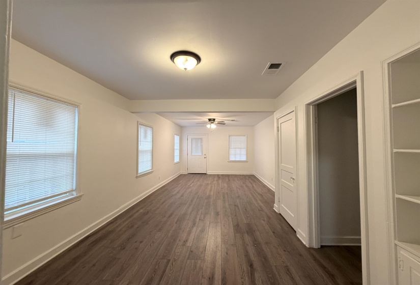 Empty room with dark wood-type flooring and ceiling fan