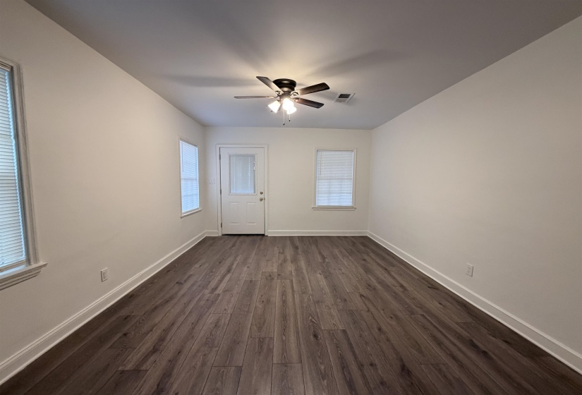 Spare room with dark wood-type flooring and ceiling fan