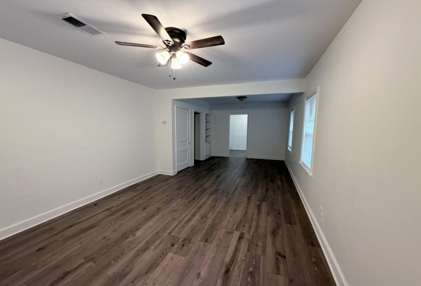 Spare room featuring dark wood-type flooring and ceiling fan