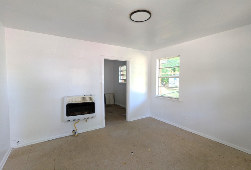 Interior space featuring white walls and a wall-mounted gas heater