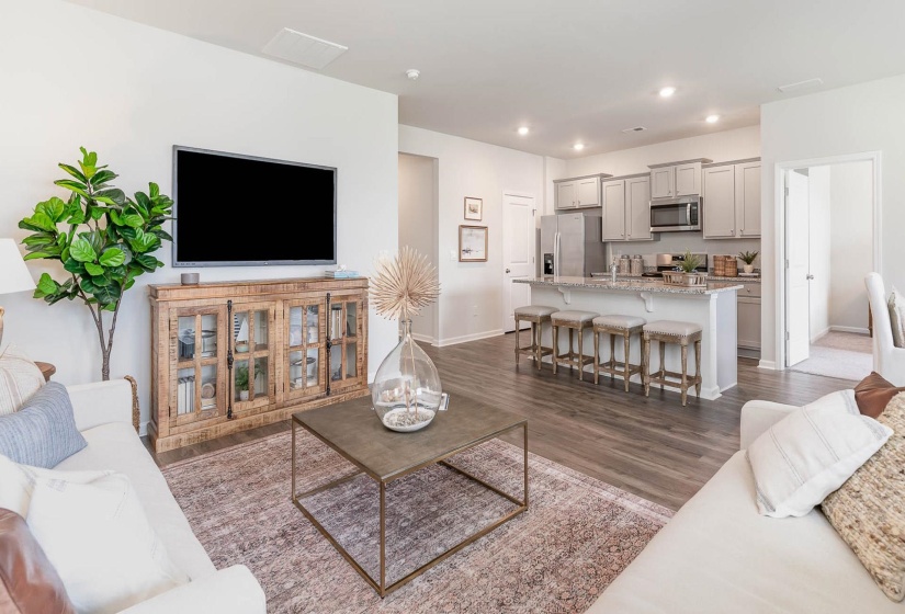 Living area featuring dark wood-type flooring and recessed lighting
