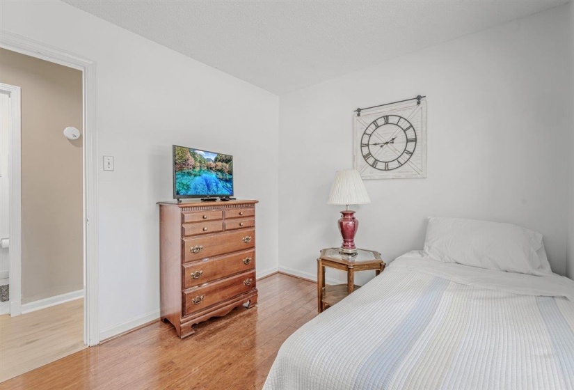 Bright room featuring wood-finish flooring, white painted walls, and a white ceiling