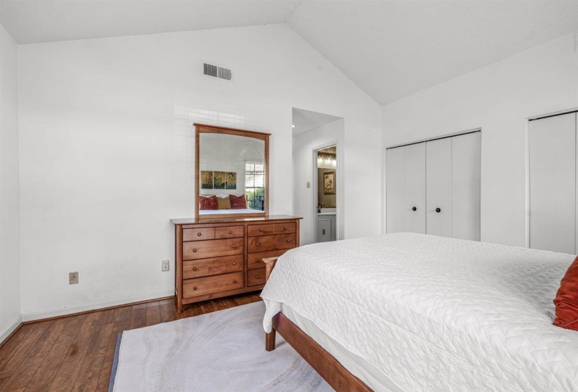 Bedroom featuring a vaulted ceiling and wood-finish flooring